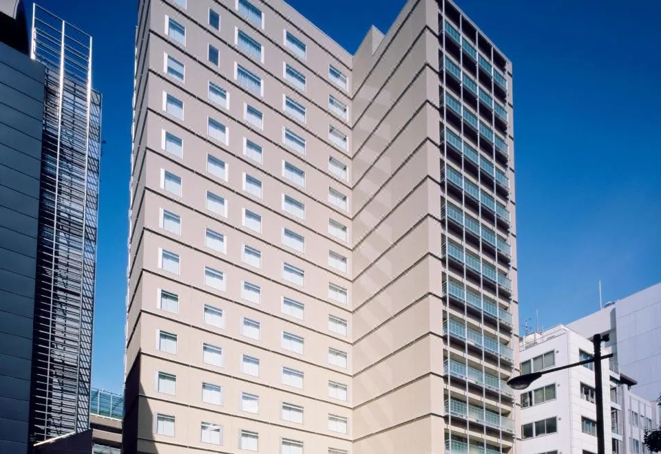 Hochhaus des Tokyo Dome Hotel unter blauem Himmel