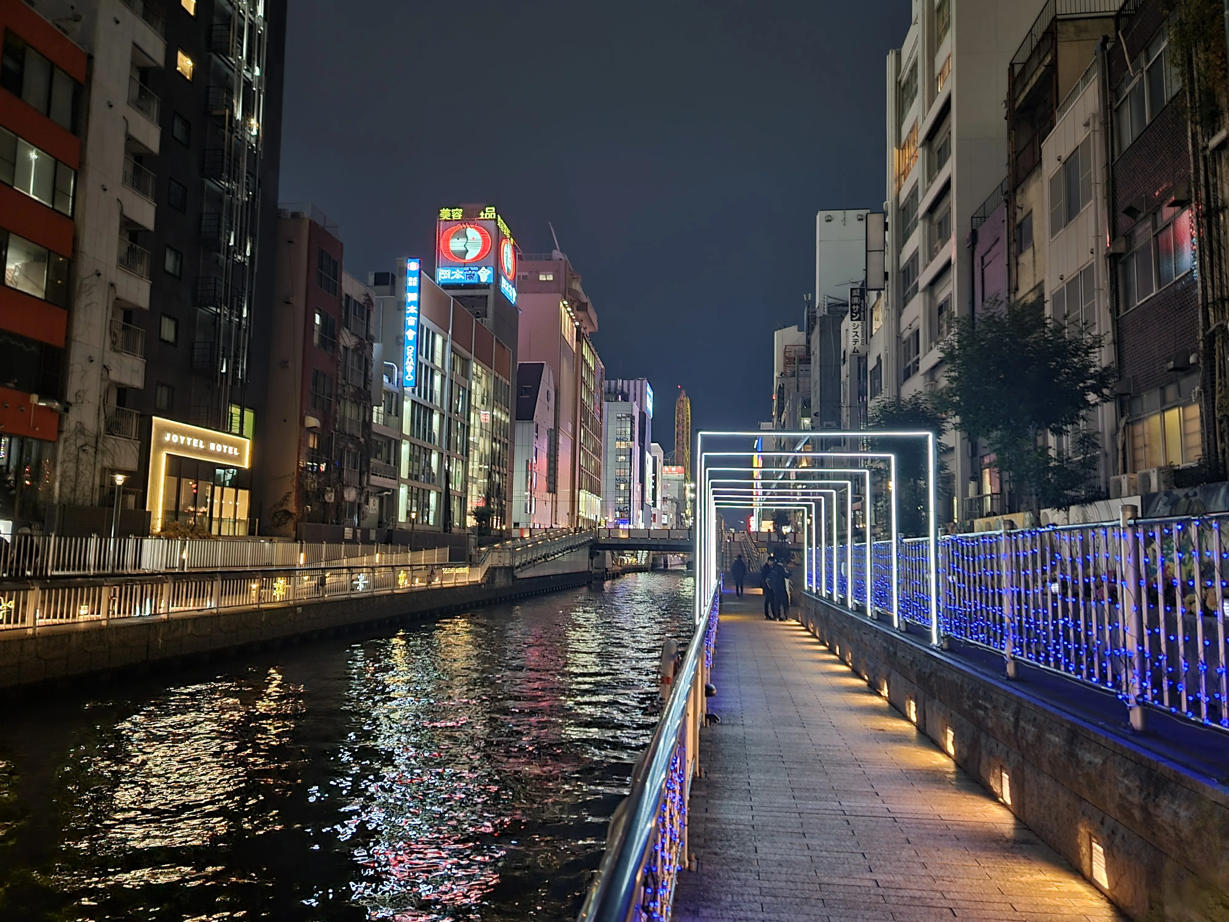 Bahnhof Osaka mit großem Glasdach zwischen Hochhäusern