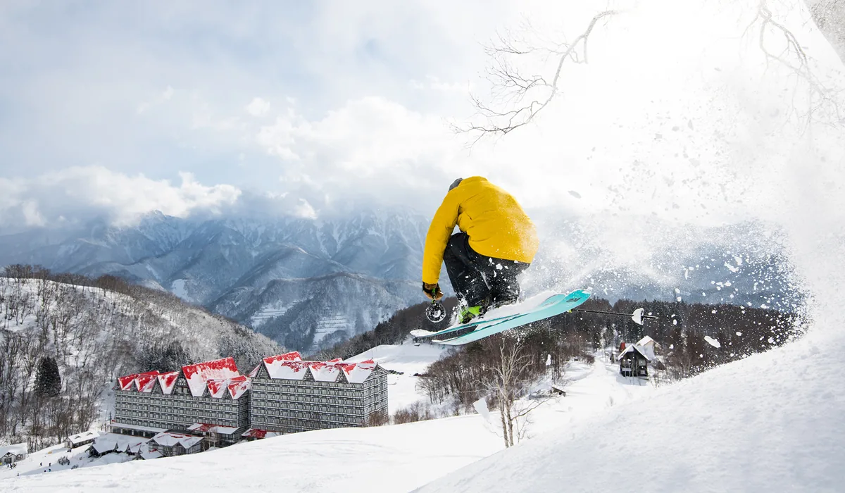 Skifahrer vor dem Hotel Green Plaza Hakuba an der Cortina-Piste